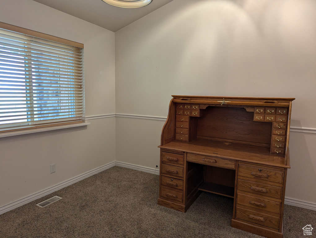 Unfurnished office with carpet flooring, baseboards, and visible vents