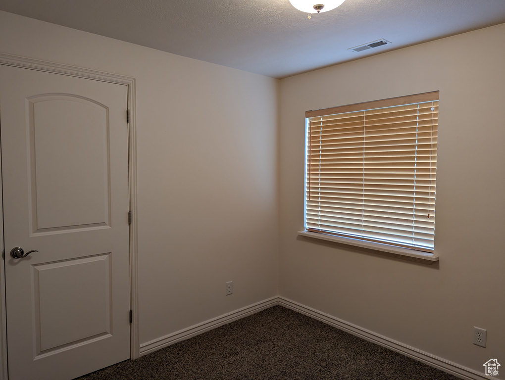 Empty room with visible vents, baseboards, and carpet floors