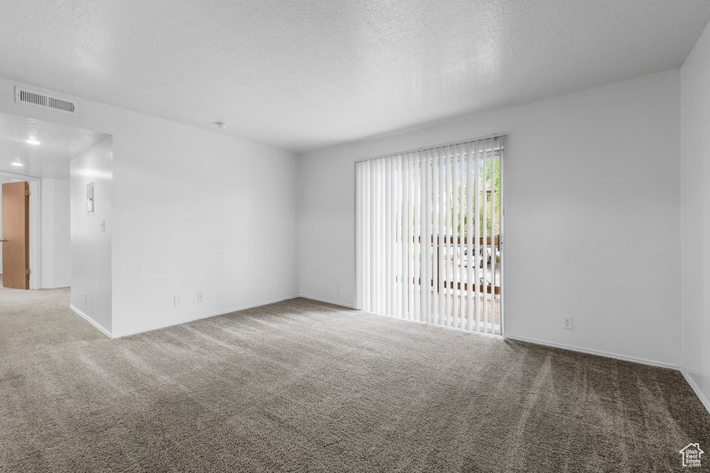 Carpeted empty room featuring baseboards and visible vents