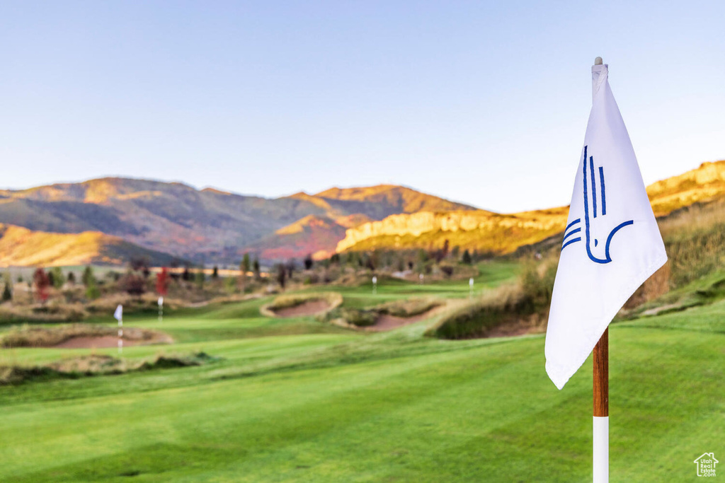 View of property's community featuring view of golf course, a mountain view, and a lawn