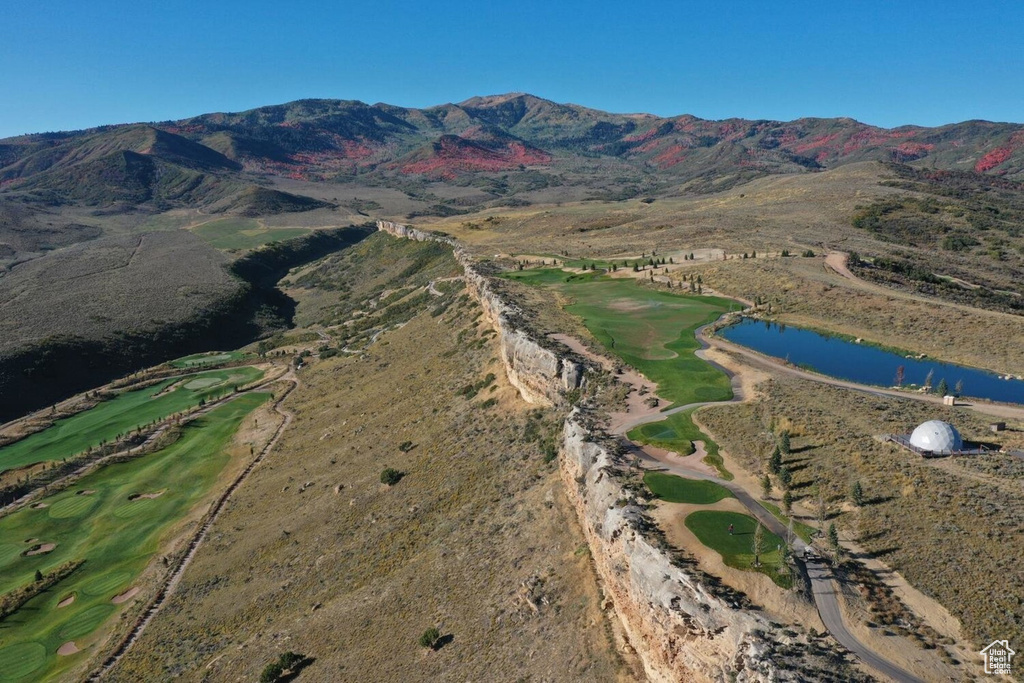 Birds eye view of property with view of golf course and a water and mountain view