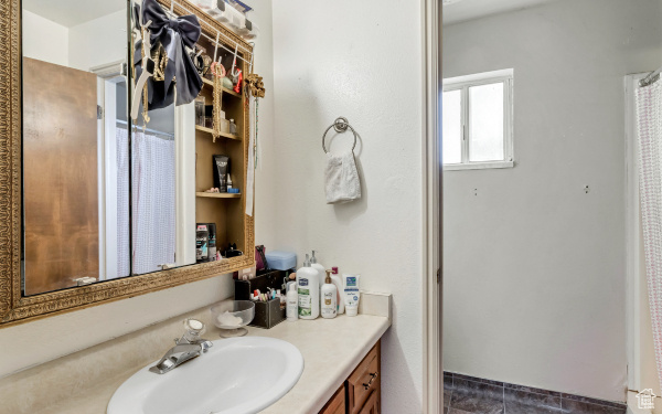 Full bathroom featuring tile patterned floors and vanity