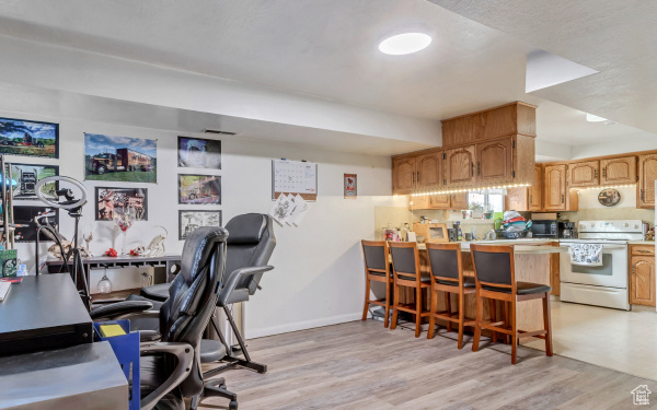 Office area with baseboards and light wood-style flooring