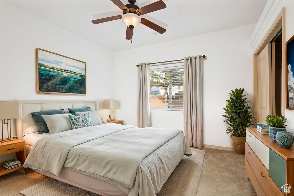 Bedroom with light carpet, baseboards, and a ceiling fan