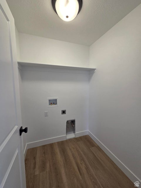 Washroom with baseboards, washer hookup, wood finished floors, hookup for an electric dryer, and laundry area