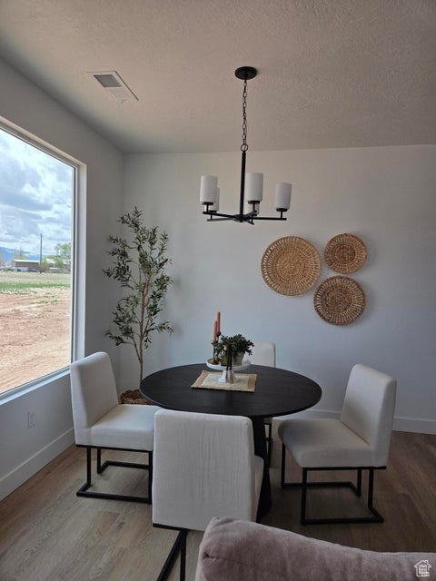 Dining area featuring baseboards, an inviting chandelier, and wood finished floors