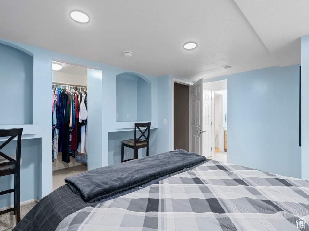Carpeted bedroom featuring baseboards, a spacious closet, a closet, and recessed lighting