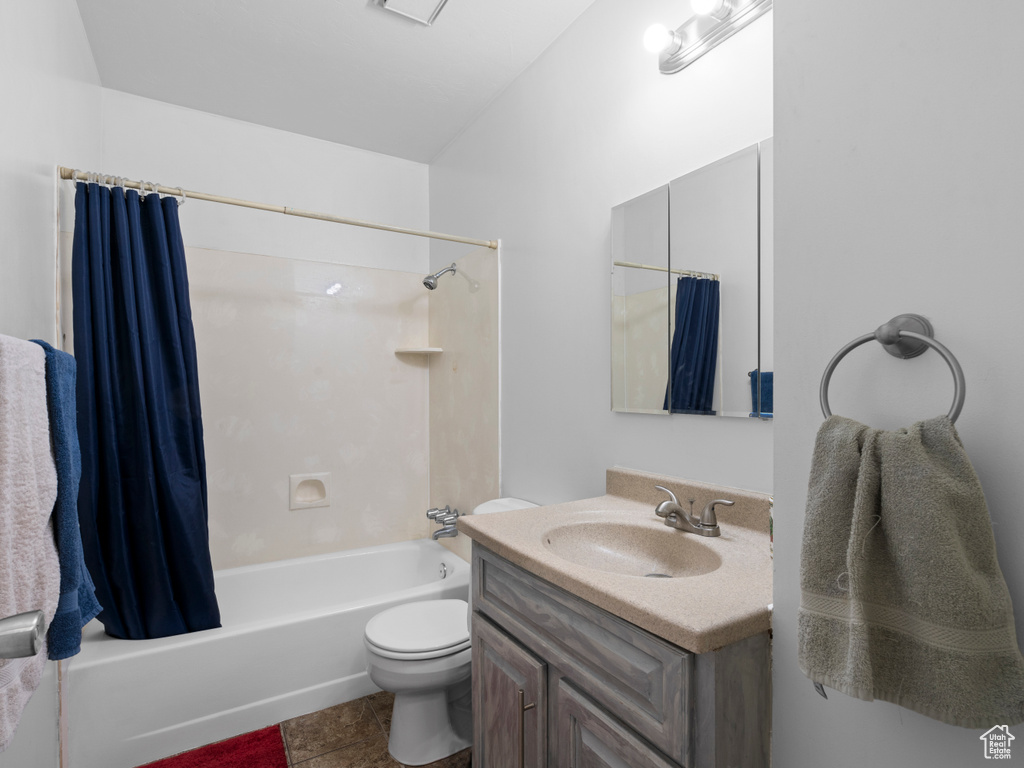 Full bathroom featuring toilet, tile patterned flooring, vanity, and shower / bath combo with shower curtain