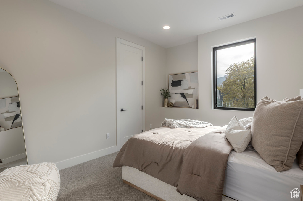 Carpeted bedroom with visible vents, baseboards, and recessed lighting