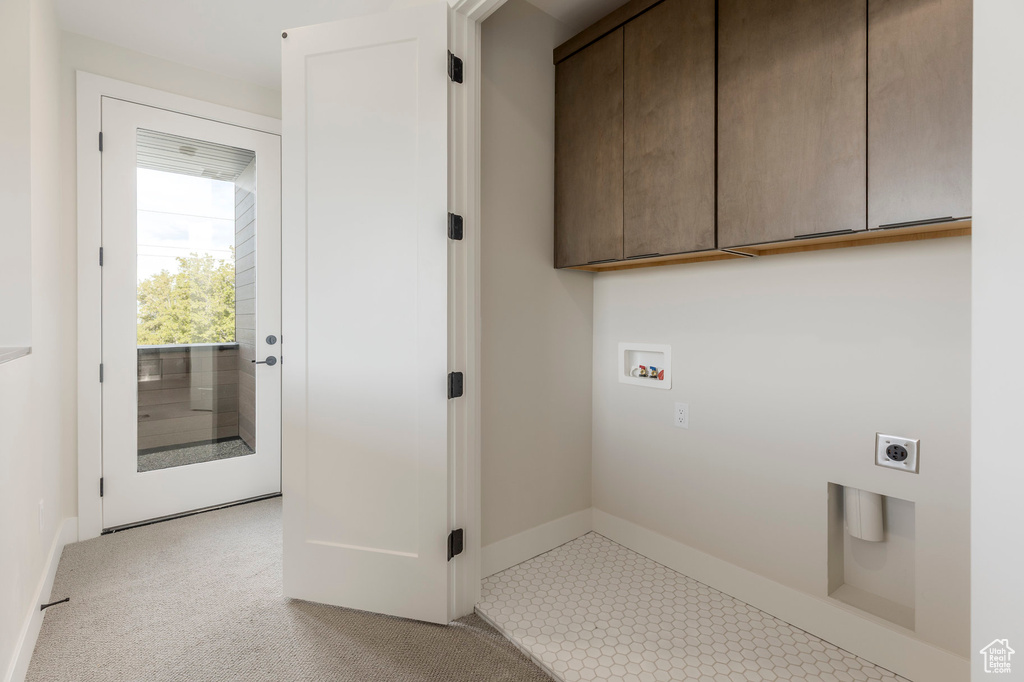 Clothes washing area with baseboards, washer hookup, cabinet space, and electric dryer hookup