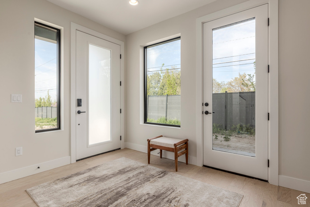 Doorway to outside with light wood-style flooring, baseboards, and recessed lighting