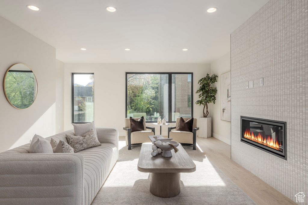 Living area with recessed lighting, baseboards, an accent wall, light wood-style floors, and a fireplace