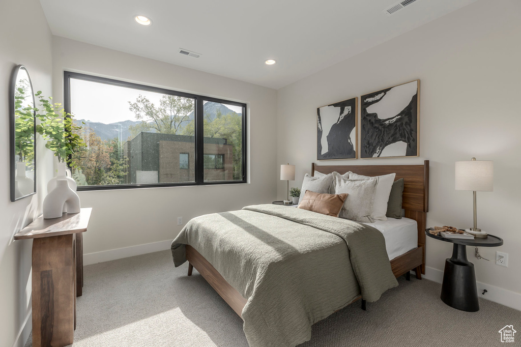 Bedroom featuring light carpet, baseboards, and visible vents