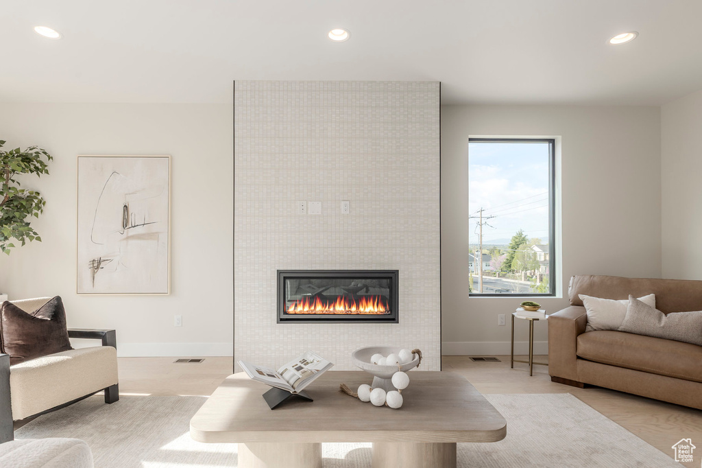 Living area featuring baseboards, a tile fireplace, visible vents, and recessed lighting