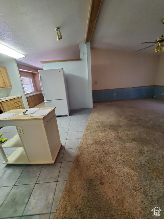 Kitchen featuring freestanding refrigerator, a ceiling fan, and light tile patterned floors