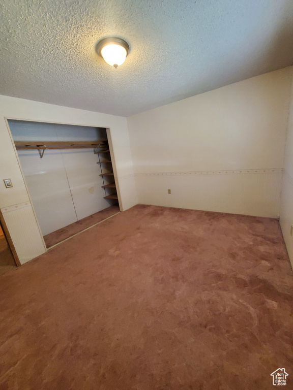 Unfurnished bedroom with a closet, carpet flooring, and a textured ceiling