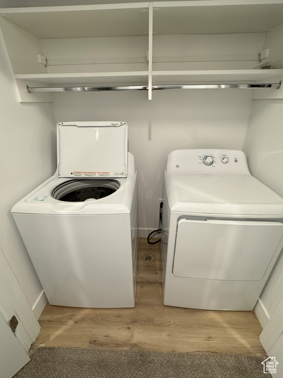 Laundry area featuring washer and dryer, laundry area, and wood finished floors