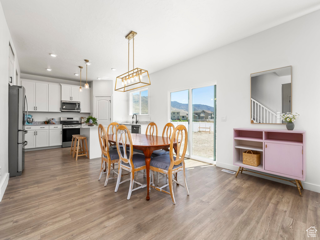 Dining room with baseboards, recessed lighting, and wood finished floors