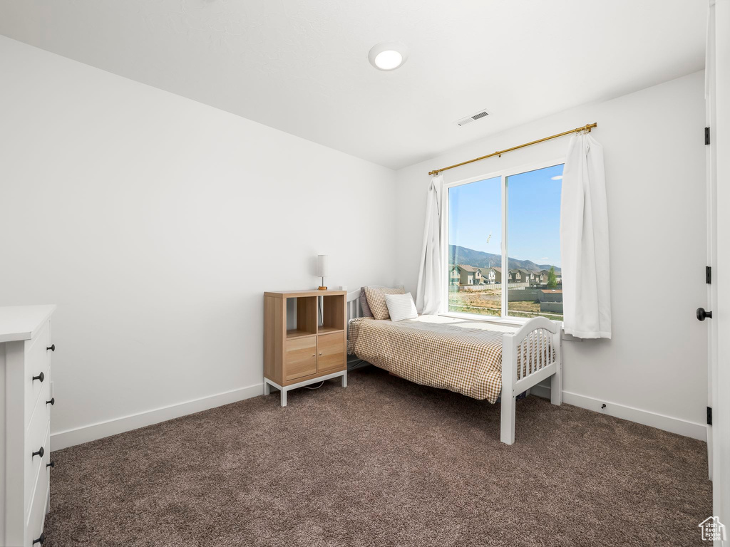 Carpeted bedroom featuring visible vents and baseboards