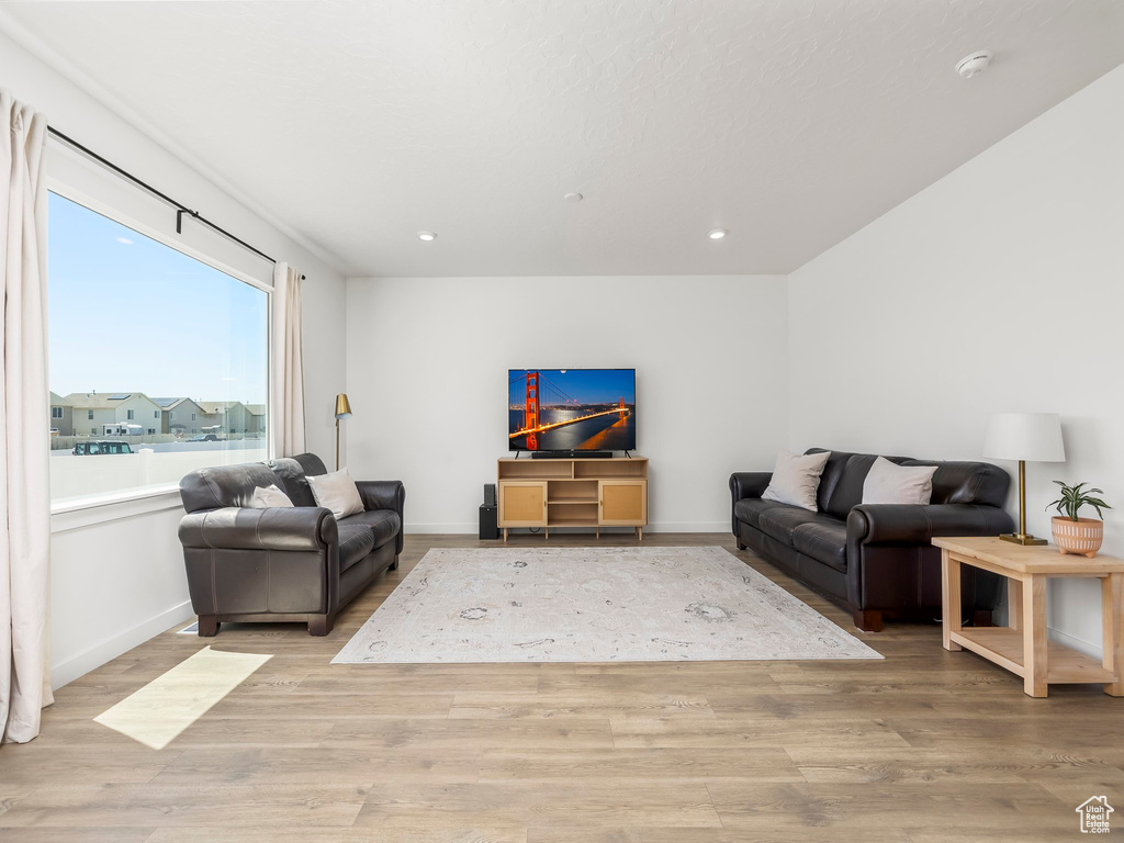 Living area featuring recessed lighting, baseboards, and light wood-style floors