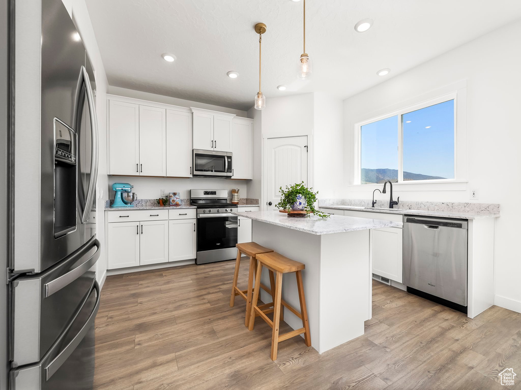 Kitchen with white cabinetry, recessed lighting, appliances with stainless steel finishes, and a kitchen island