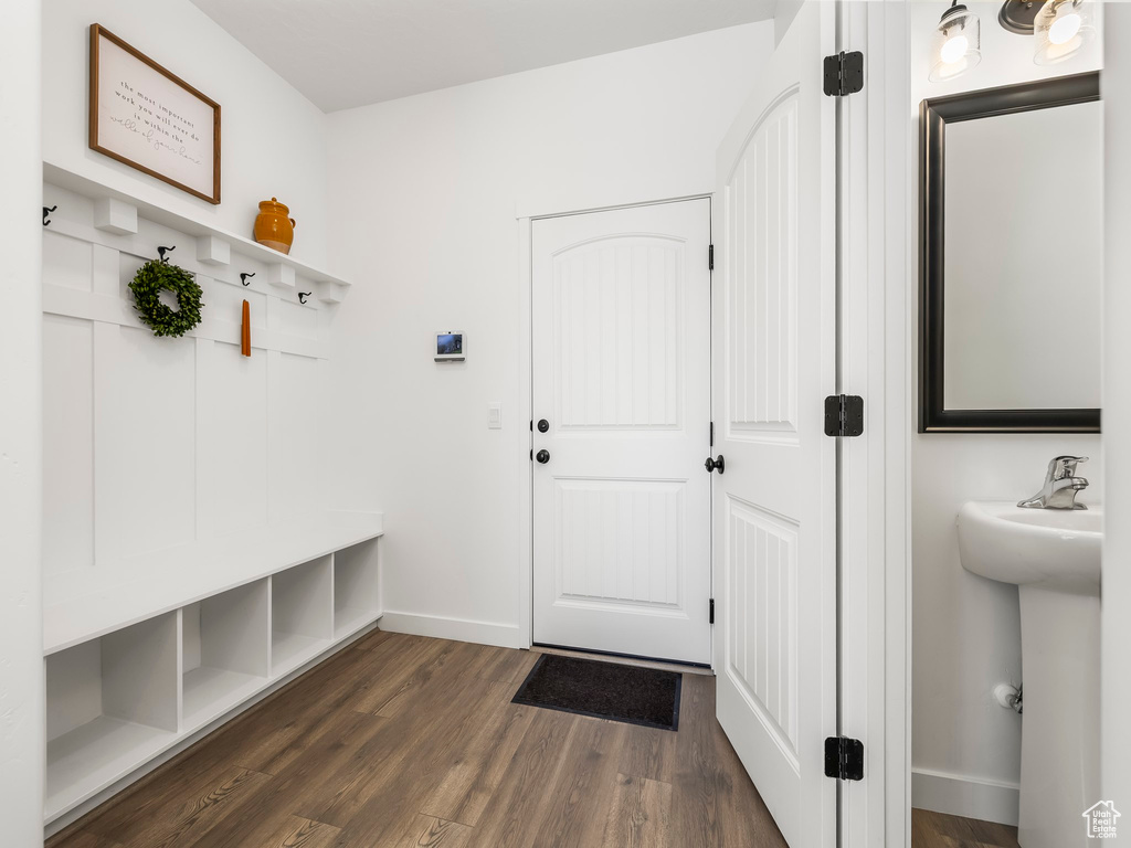 Mudroom featuring dark wood-style flooring, baseboards, and a sink