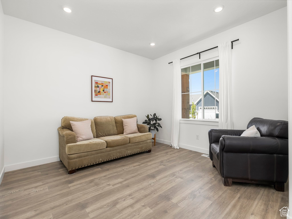 Living area with baseboards, light wood finished floors, and recessed lighting