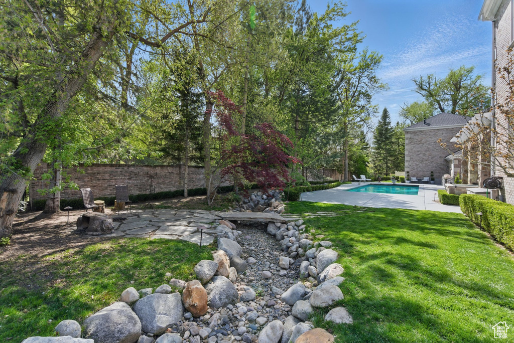 View of yard with fence, a patio, and a fenced in pool