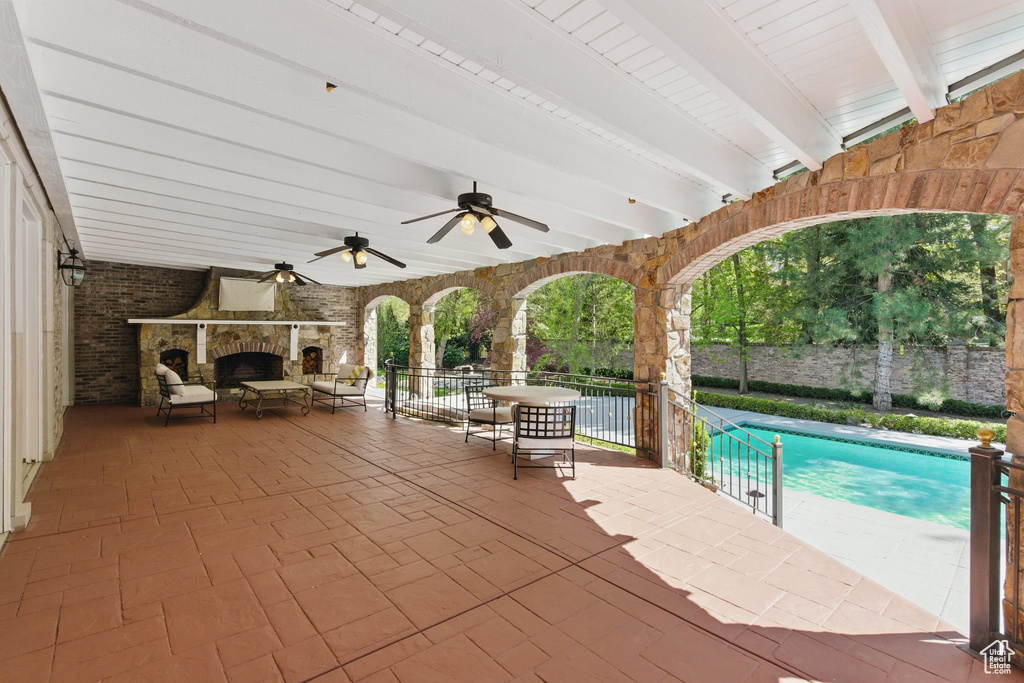 View of patio / terrace with fence, outdoor lounge area, a ceiling fan, and an outdoor pool