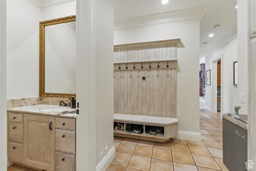 Mudroom featuring recessed lighting, crown molding, light tile patterned flooring, and a sink