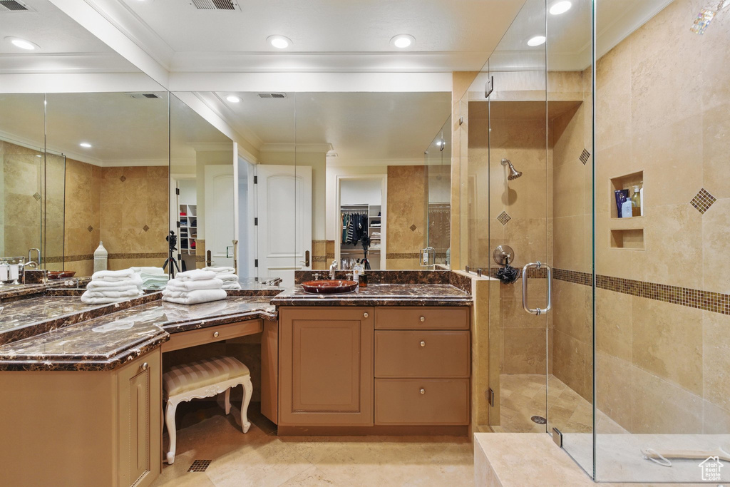 Full bathroom featuring ornamental molding, vanity, a shower stall, and a spacious closet