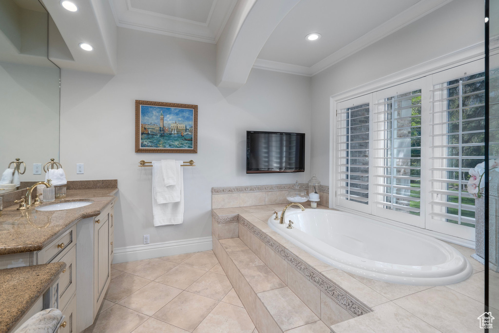 Bathroom with a garden tub, tile patterned flooring, vanity, ornamental molding, and recessed lighting