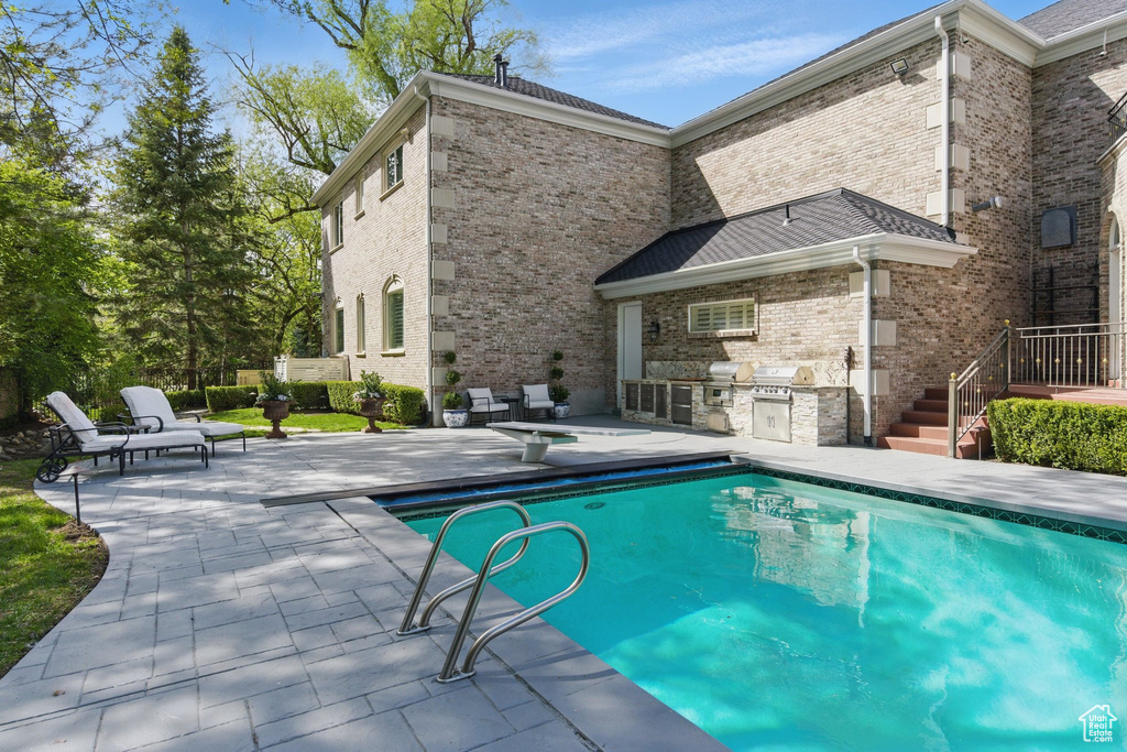 Outdoor pool featuring a patio area, area for grilling, and grilling area