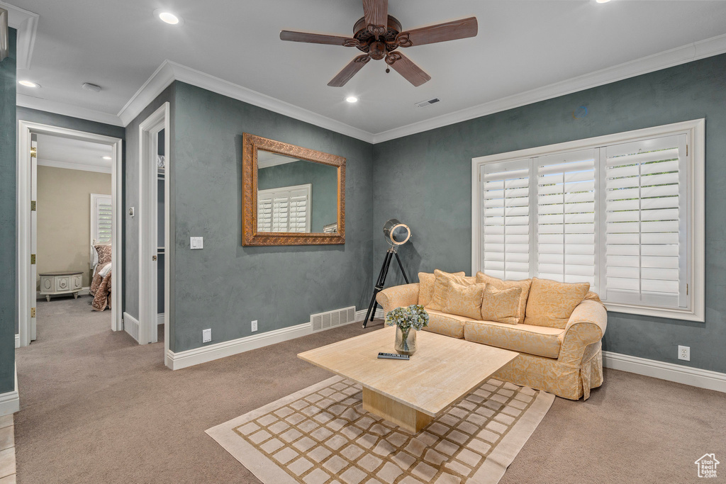 Carpeted living area featuring crown molding, a ceiling fan, visible vents, and recessed lighting