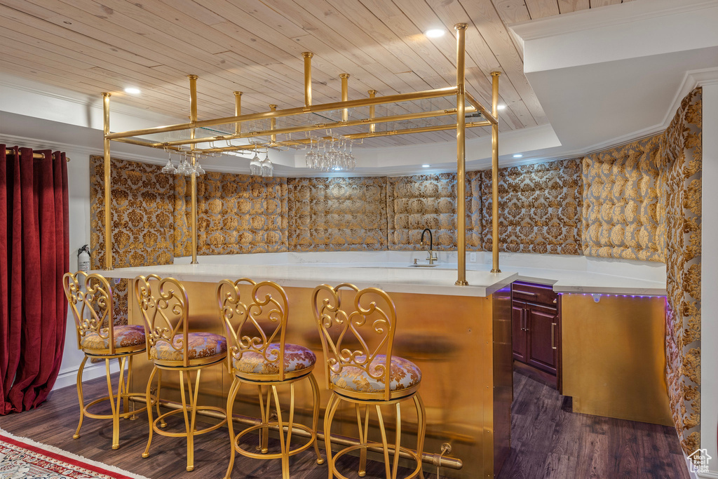 Bar with wet bar, wooden ceiling, dark wood-style flooring, and a sink