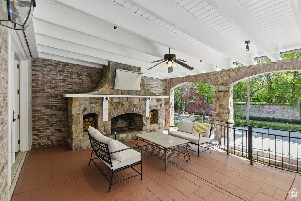 View of patio / terrace with an outdoor stone fireplace and ceiling fan