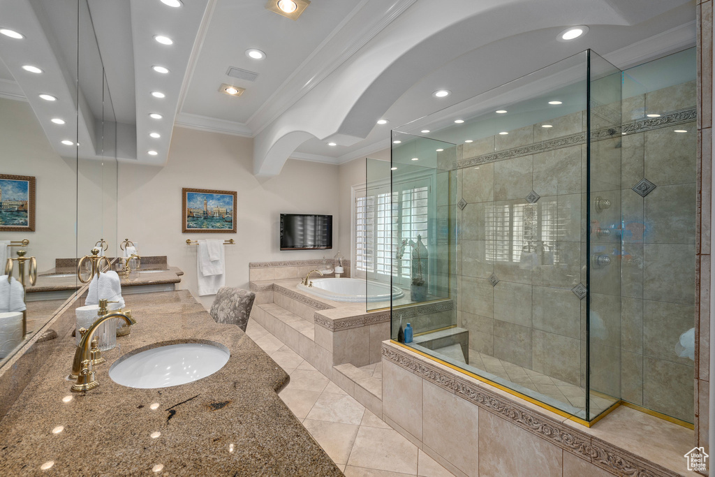 Bathroom featuring vanity, tile patterned floors, crown molding, a bath, and a tile shower