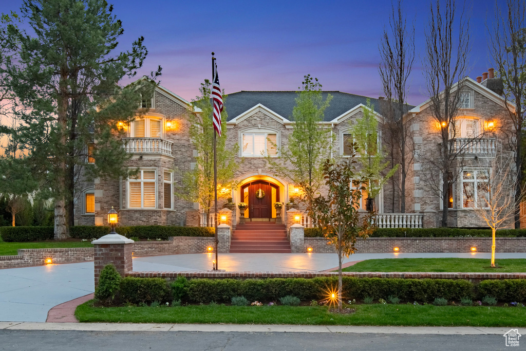 View of front of property with stone siding and a balcony