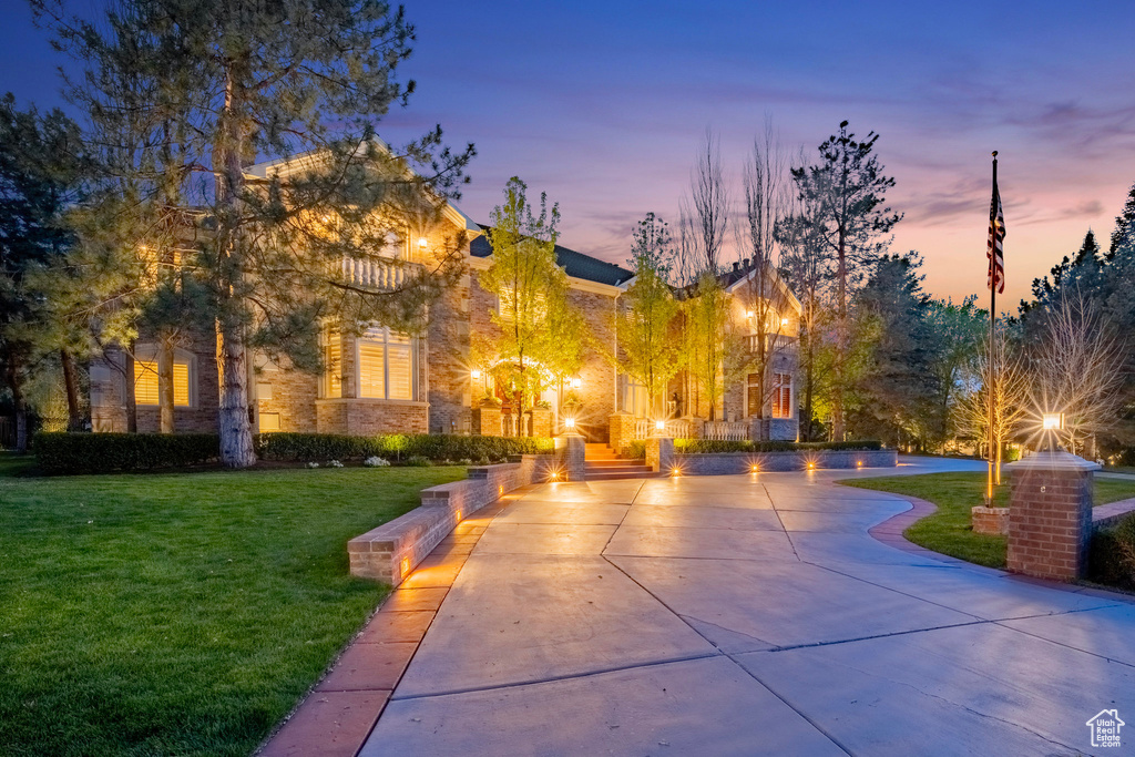 View of community with curved driveway and a lawn