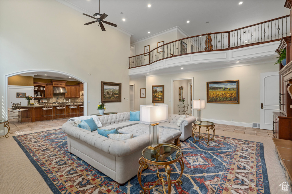 Living area featuring recessed lighting, visible vents, ceiling fan, crown molding, and a high ceiling