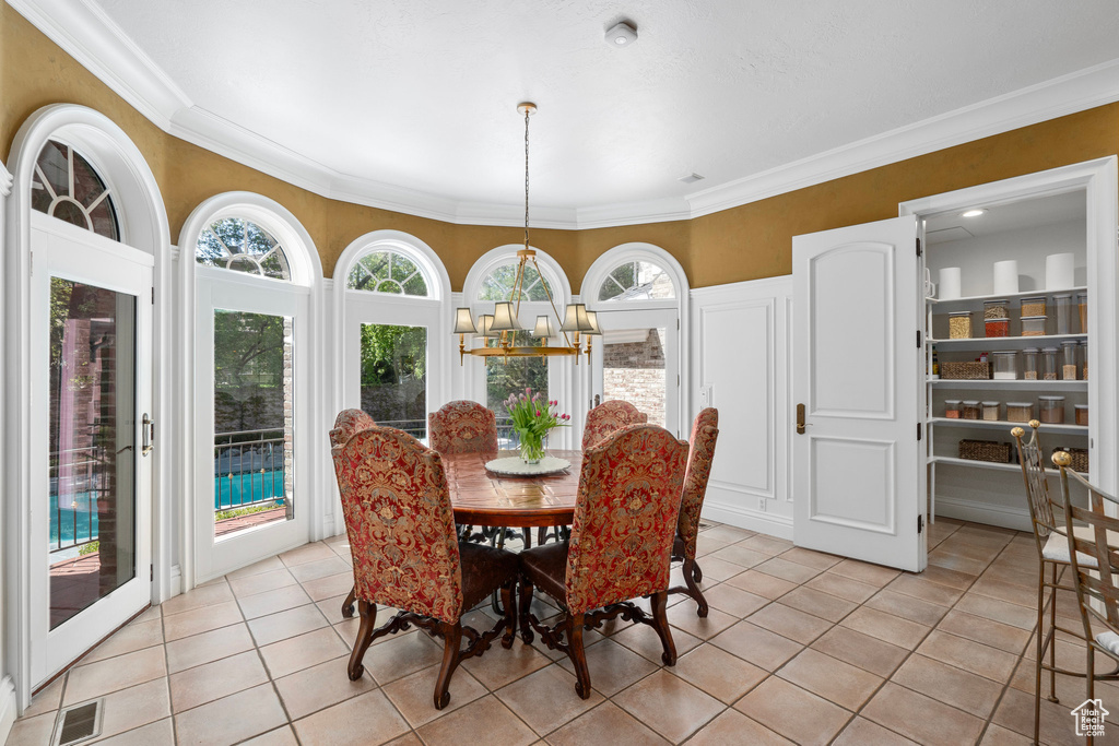 Dining space featuring light tile patterned floors, crown molding, and visible vents