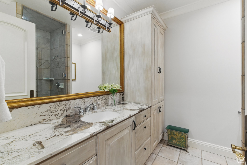 Bathroom with a stall shower, tile patterned floors, vanity, and crown molding