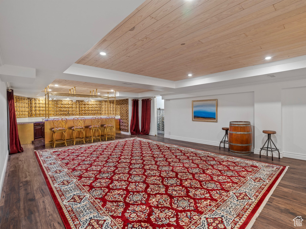 Interior space featuring wood ceiling, baseboards, dark wood-style floors, and bar area