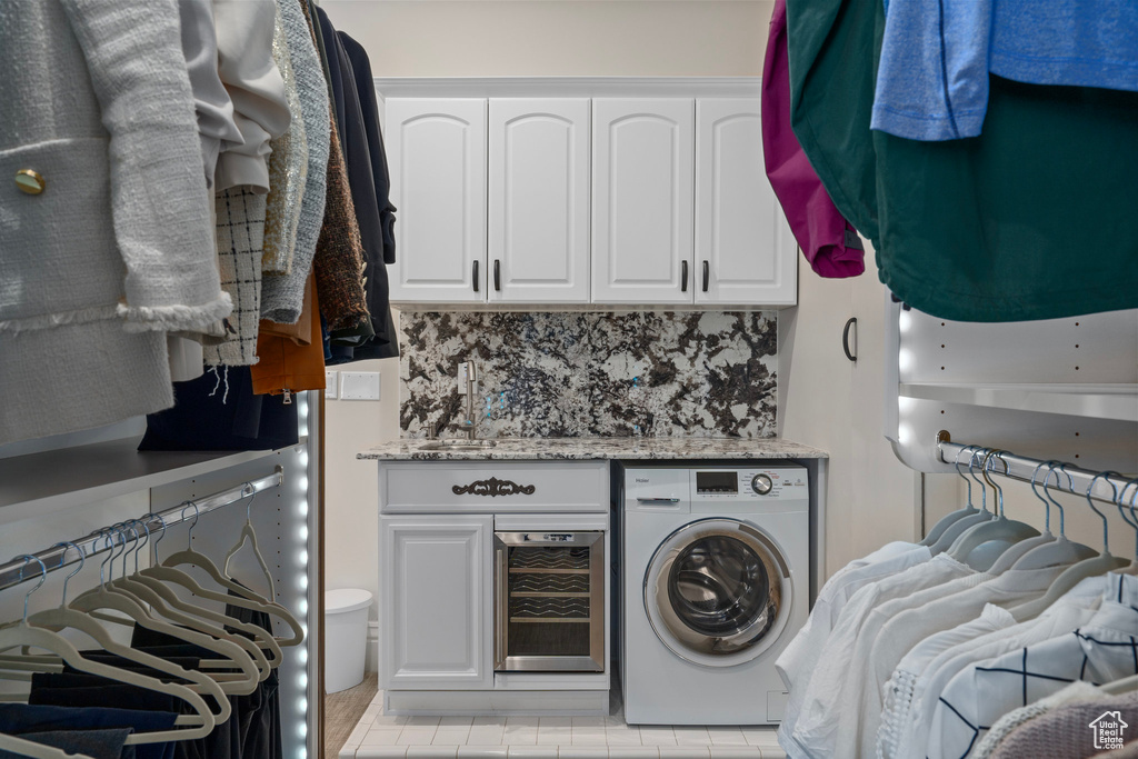 Laundry area with washer / clothes dryer, cabinet space, and beverage cooler