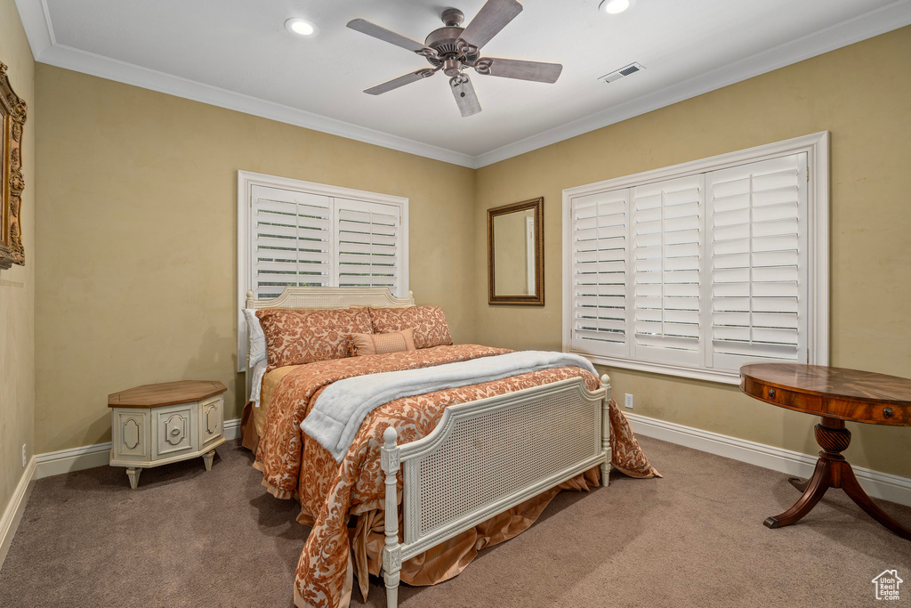 Carpeted bedroom with ornamental molding, baseboards, visible vents, and recessed lighting