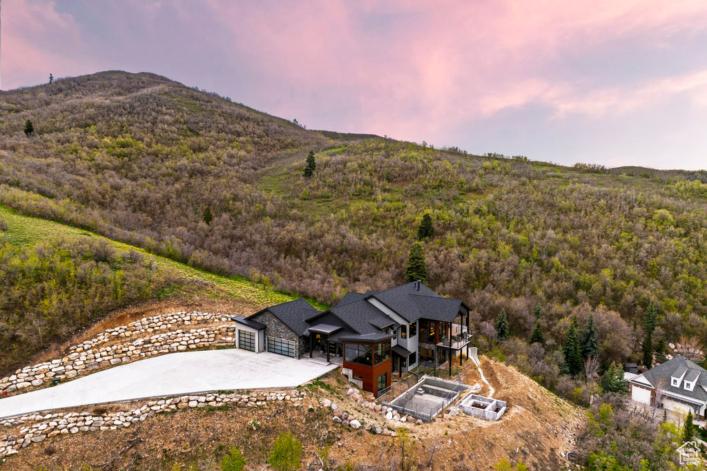 Birds eye view of property with a mountain view and a view of trees