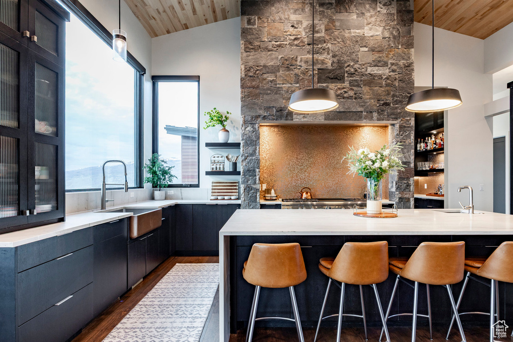 Kitchen with a wealth of natural light, dark wood finished floors, a sink, and wood ceiling