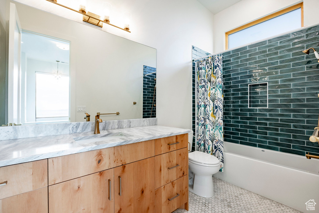 Full bath featuring toilet, tile patterned flooring, vanity, and shower / bath combination with curtain