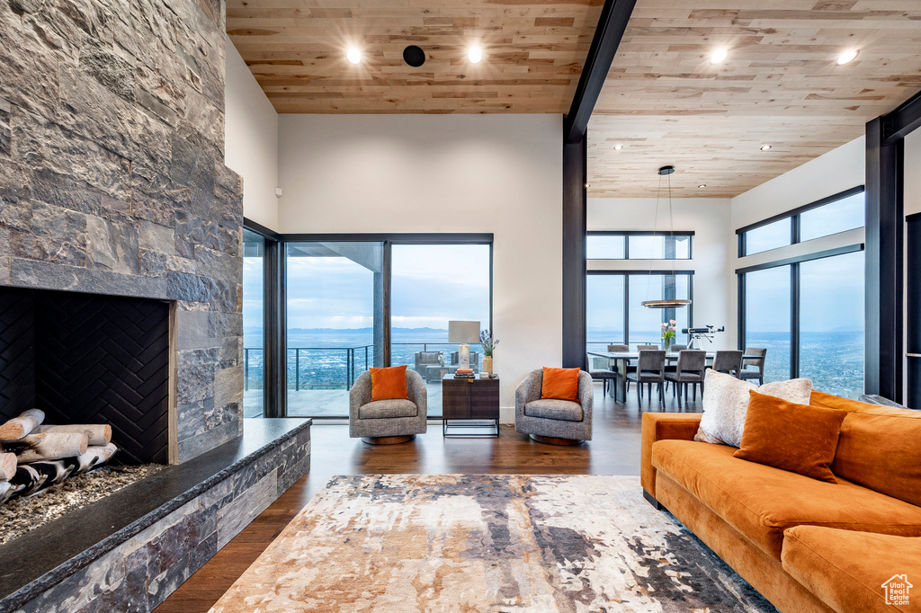 Living room featuring a towering ceiling, wood ceiling, recessed lighting, and wood finished floors