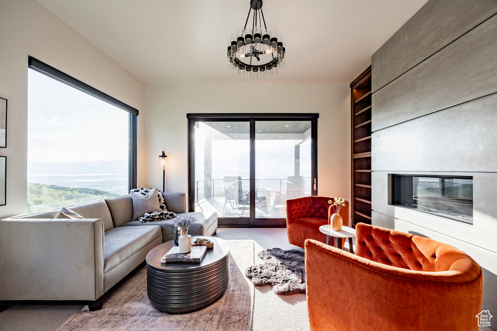 Carpeted living room featuring built in features and a glass covered fireplace